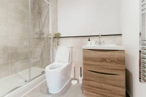 y baño con aseo, ducha y lavamanos. en Pacific Suite - Wyndale Living- BHam JQ Lux 2 BR, en Birmingham