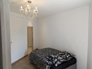 1 dormitorio con cama y lámpara de araña en Gite de Marcella en Saint-Dizier-Leyrenne