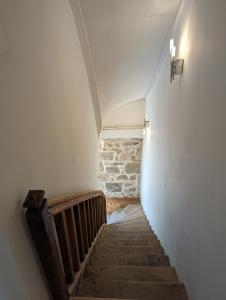 a hallway with a staircase with a stone wall at Gite de Marcella in Saint-Dizier-Leyrenne