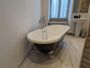 a bath tub in a bathroom with a sink at Gite de Marcella in Saint-Dizier-Leyrenne