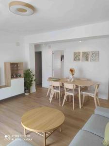 een woonkamer met een tafel en stoelen en een keuken bij Apartamento en el puerto in Denia