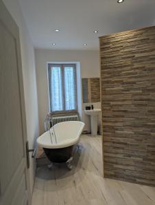 a bath tub in a bathroom with a wooden door at Gite de Marcella in Saint-Dizier-Leyrenne