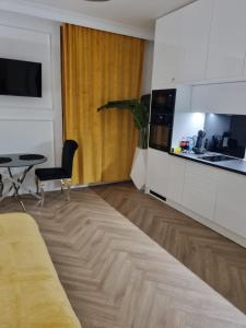 een woonkamer met een bank en een tafel en een keuken bij SKYAPART in Kłodzko