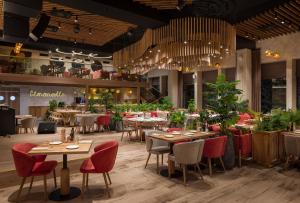 un restaurante con mesas, sillas y plantas en Apartel Uzhhorod, en Uzhhorod