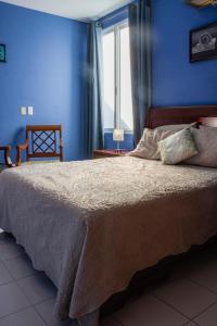 a bedroom with a large bed with a blue wall at Hotel Gran Domo in León