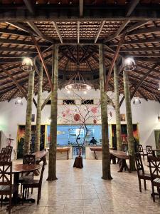 Cirandeira Amazon World EcoResort في Manacapuru: غرفة كبيرة بها طاولات وكراسي وجدارية