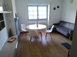 - un salon avec une table, des chaises et un canapé dans l'établissement Venanzio!, à Pianello Del Lario