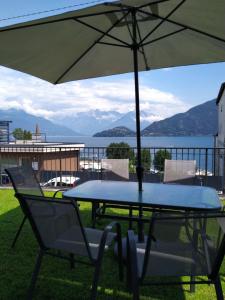 einen Tisch und Stühle mit Sonnenschirm auf dem Balkon in der Unterkunft Venanzio! in Pianello Del Lario