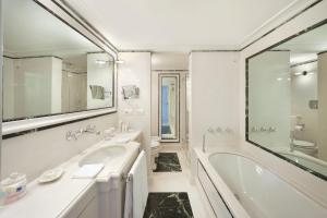 La salle de bains blanche est pourvue d'une baignoire et d'un lavabo. dans l'établissement Il San Pietro di Positano, à Positano