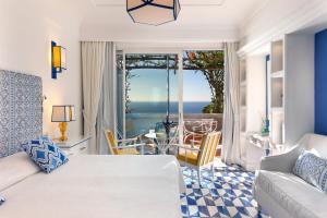 a living room with a bed and a table with chairs at Il San Pietro di Positano in Positano