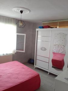 1 dormitorio con 1 cama rosa y armario en Mete konaklari en Rize