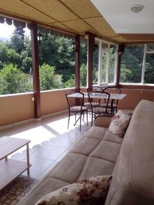 een woonkamer met een bank en tafels en stoelen bij Mete konaklari in Rize