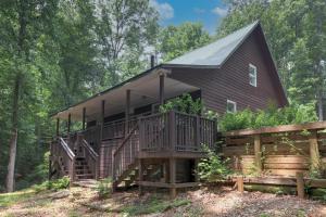 a cabin in the woods with a large deck at The Haggai House in Demorest
