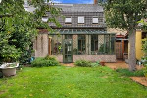 una casa con salón acristalado en un patio en BNB 't Oud Schooltje, en Stavelhoekje