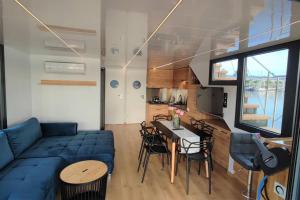 ein Wohnzimmer mit einem blauen Sofa und einem Tisch in der Unterkunft Houseboat Water King apartament pływający dom na wodzie łódź Hausboot 7 os in Uraz