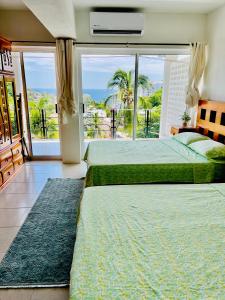 1 dormitorio con 2 camas y ventana grande en CasaBlancaGrand Colibrí en Acapulco