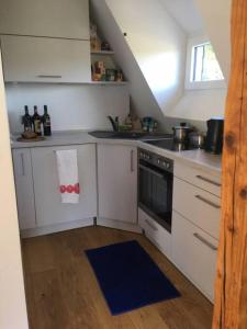 a kitchen with white cabinets and a stove top oven at Ferienwohnung Rheinblick, Sport-Pool in Koblenz