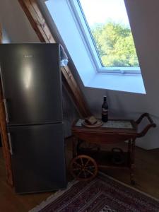 eine Küche mit einem Kühlschrank und einem Tisch mit einem Fenster in der Unterkunft Ferienwohnung Rheinblick, ruhig, Aussicht, Gartennutzung, Sport-Pool in Koblenz