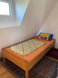 a wooden bed in a room with a window at Ferienwohnung Rheinblick, ruhig, Aussicht, Gartennutzung, Sport-Pool in Koblenz