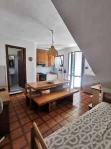 a living room with a table and a kitchen at Casa Pineta in Procchio