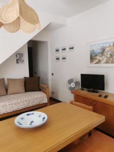 ein Wohnzimmer mit einem Tisch und einem Sofa in der Unterkunft Casa Pineta in Procchio