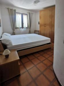 ein Schlafzimmer mit einem großen Bett und einem Fenster in der Unterkunft Casa Pineta in Procchio