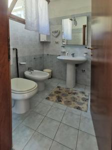 a bathroom with a toilet and a sink at Casa Pineta in Procchio +25 photos