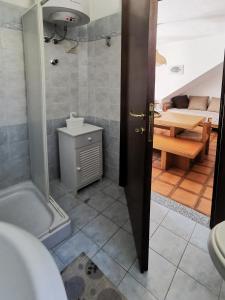 La salle de bains est pourvue d'une douche, d'un lavabo et d'une table. dans l'établissement Casa Pineta, à Procchio