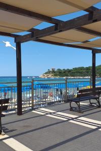 - une vue sur la plage depuis une terrasse avec bancs dans l'établissement Casa Pineta, à Procchio