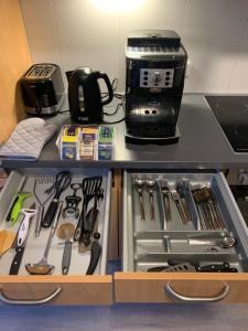 un armadio con cassetto pieno di utensili da cucina di Ferienwohnung ganz nah am Förderturm Zeche Zollverein a Essen