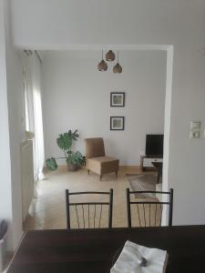 ein Wohnzimmer mit einem Stuhl und einem Sofa in der Unterkunft Four Reasons Apts Ampelokipi in Thessaloniki
