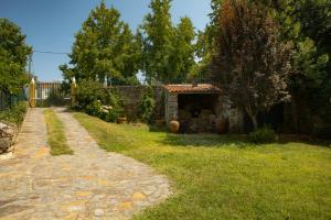 a garden with a stone house and a path at A Sobreirinha Jacuzzi e Pet Friendly in Sobreira Formosa