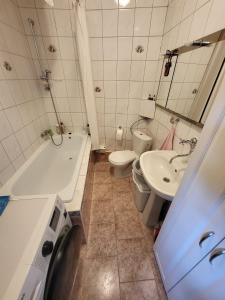 a bathroom with a sink and a tub and a toilet at Zabytkowa Kamienica in Gdańsk