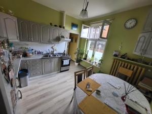 a kitchen with a table and a clock on the wall at Zabytkowa Kamienica in Gdańsk