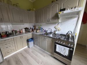 a kitchen with stainless steel appliances and wooden floors at Zabytkowa Kamienica in Gdańsk