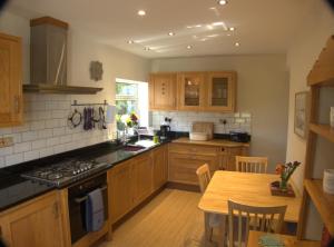 a kitchen with wooden cabinets and a wooden table with a tableablish at The Cwtch in Haverfordwest