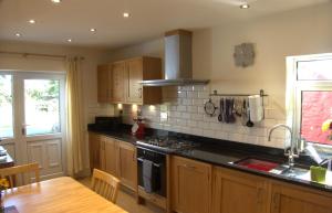 a kitchen with wooden cabinets and a stove top oven at The Cwtch in Haverfordwest