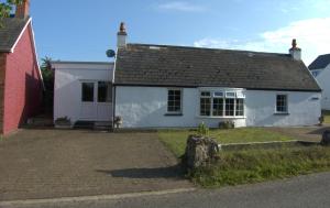 een klein wit huis met een zwart dak bij The Cwtch in Haverfordwest