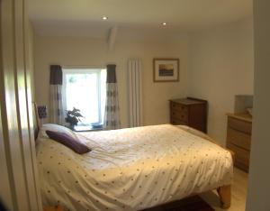 a bedroom with a bed and a window at The Cwtch in Haverfordwest
