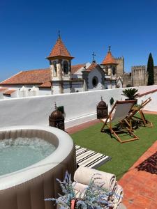 a patio with a hot tub and a chair and a building at Alter Village Apartments in Alter do Chão