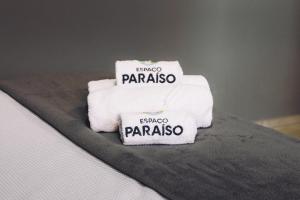 - une pile de serviettes assises au-dessus d'un lit dans l'établissement Espaço Paraíso Ortigueira, à Ortigueira