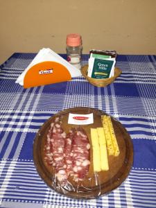 a table with a plate of meat and cheese on it at Valentino Apart I in Jesús María
