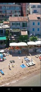 - une plage avec des chaises, des parasols et des personnes sur le sable dans l'établissement Apartments Langust, à Sveti Stefan