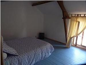 a bedroom with a white bed and a window at La Ferme de la Petite Noé in Tracy-sur-Mer