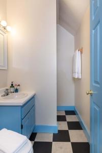 ein Badezimmer mit einem Waschbecken und einer blauen Tür in der Unterkunft Old Stagecoach Inn in Waterbury