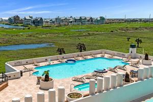 an outdoor swimming pool with chairs and a golf course at 8th Floor Penthouse Luxury Beautifully Remodeled in Port Aransas