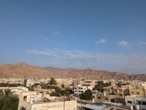 miasto z budynkami i górami w tle w obiekcie Siwar Al-Thahab Suites & Hotel Apartments w Akabie
