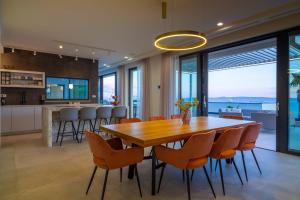 a dining room and kitchen with a wooden table and chairs at Villa Valentina in Makarska