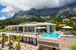 an aerial view of a house with a swimming pool and mountains at Villa Valentina in Makarska