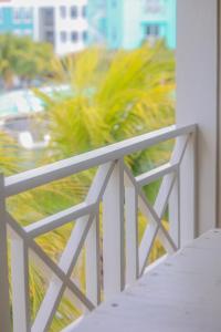 a white railing on a balcony with palm trees at Caribbean Lofts Bonaire in Kralendijk